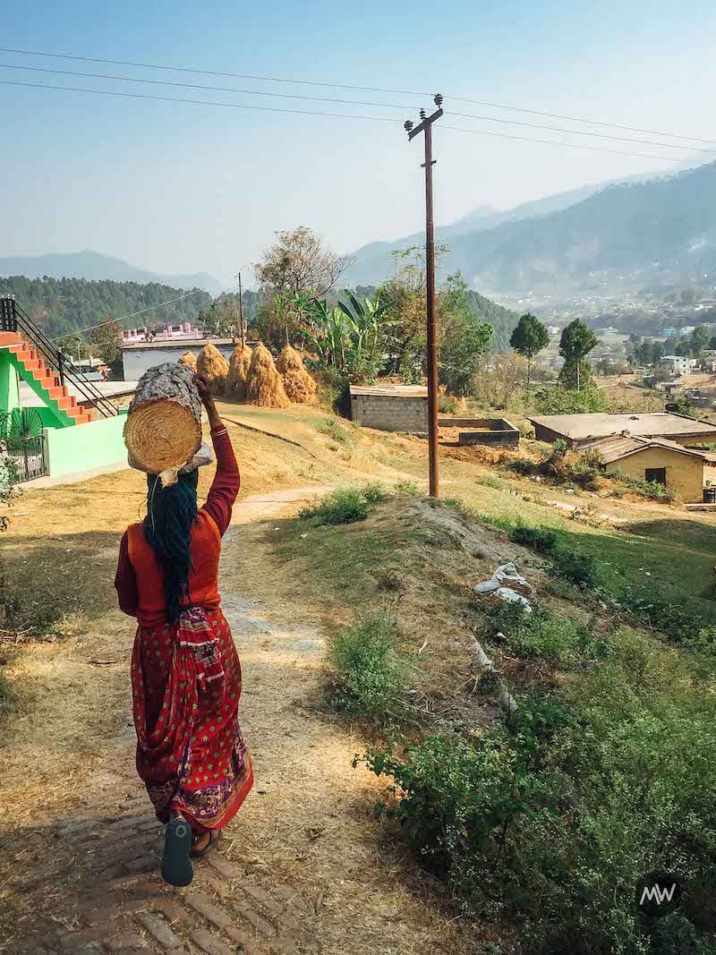 A village lady carrying a heavy wooden block in Uttarakhand