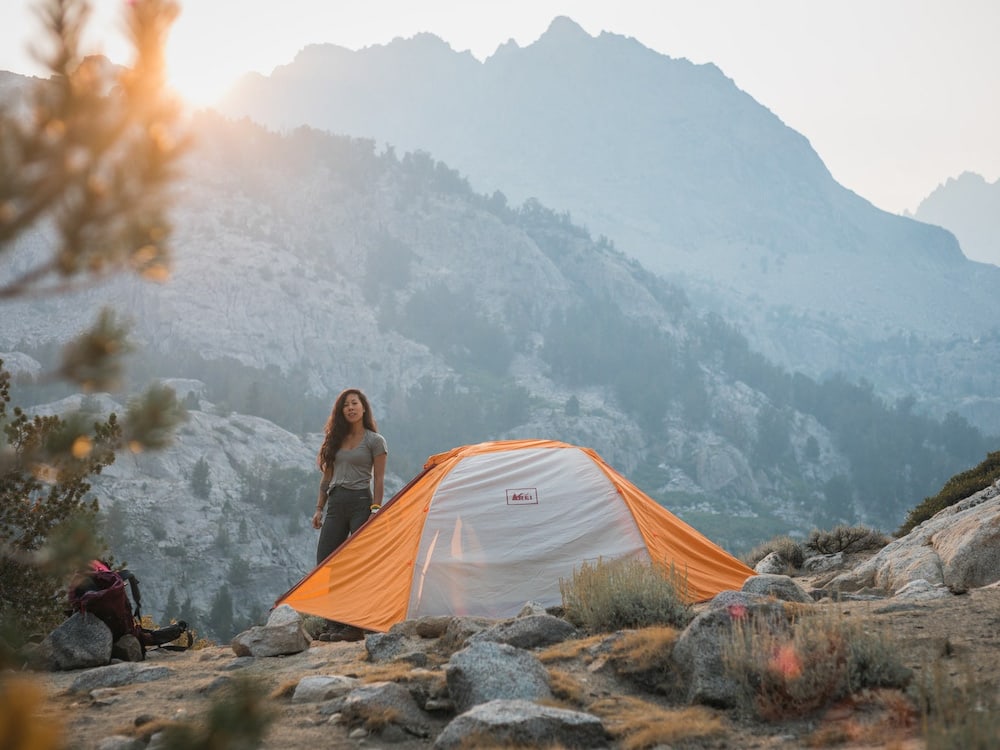Backpacking: How To Go Ultralight? (7 Tips) 2 A girl looking out of her backpacking tent