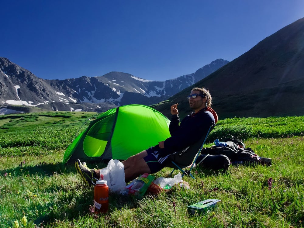 A man sitting in front of his backpacking tent
