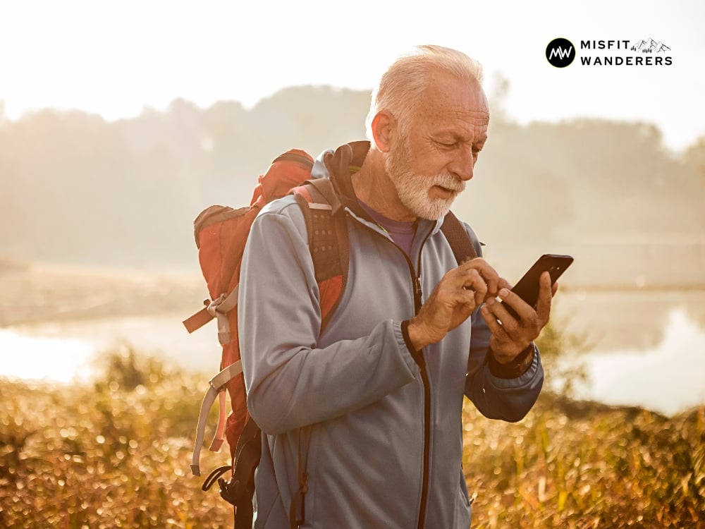 An old man hiking while using his phone — Rugged Phone Case